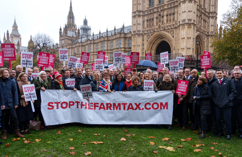 Conservative MPs in Parliament holding 'Stop the Family Farm Tax' banner.