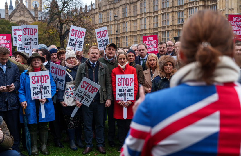 Helen and colleagues holding 'Stop the Family Farm Tax' placards in Parliament.